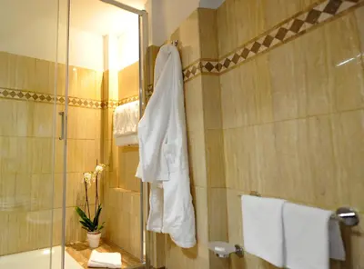 a bathroom with a shower with a towel hanging on the wall at Angel Spagna Suite in Rome