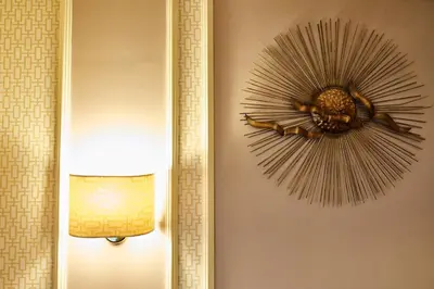 a mirror hanging on a wall next to a lamp at Domus Cavour Guest house in Rome
