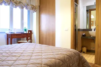 a bedroom with a bed and a bathroom with a sink at Domus Cavour Guest house in Rome