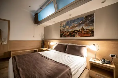 a bedroom with a bed and a large painting on the wall at Hotel Paolo II in Rome