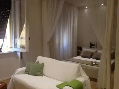 a room with two beds and a couch and a window at White Apartment in San Giovanni in Rome