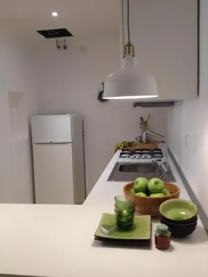 a kitchen with a bowl of apples on a counter at White Apartment in San Giovanni in Rome