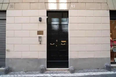 a black door on a white brick building at Kame Hall in Rome