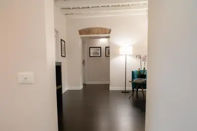 a hallway with white walls and a table and a lamp at Kame Hall in Rome