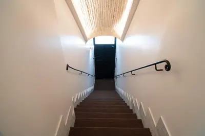 a stairway with a light at the top and a black door at Kame Hall in Rome