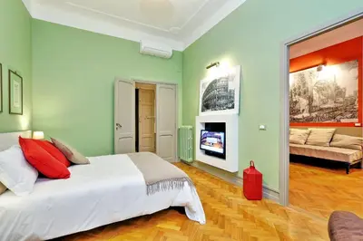 a bedroom with a large bed and a living room at Piranesi Charmsuite in Rome