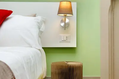 a bedroom with a bed and a lamp and a stool at Piranesi Charmsuite in Rome