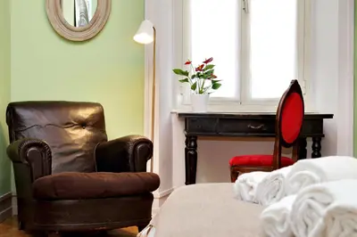 a bedroom with a bed and a chair and a window at Piranesi Charmsuite in Rome