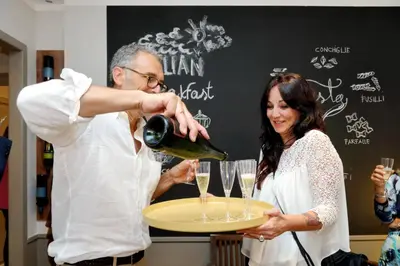 a man pouring a glass of wine for a woman at Piranesi Charmsuite in Rome