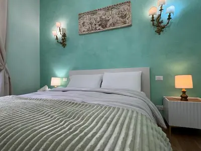 a bedroom with a large bed with blue walls at Amedeo Apartment in Rome