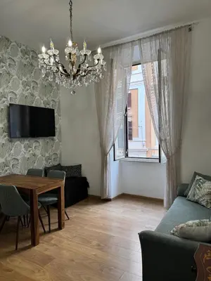 a living room with a table and a chandelier at Amedeo Apartment in Rome