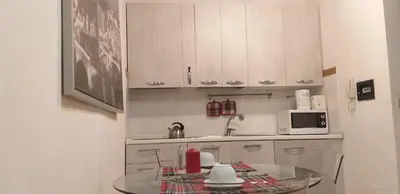 a kitchen with a glass table and a microwave at Cozy Navona Apartment in Rome