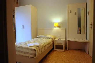 a small bedroom with a bed and a mirror at Casa per Ferie Ravasco San Pietro in Rome