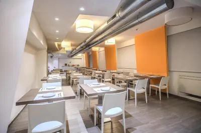 a restaurant with wooden tables and white chairs at Casa per Ferie Ravasco San Pietro in Rome