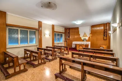 a row of wooden benches in a courtroom at Casa per Ferie Ravasco San Pietro in Rome
