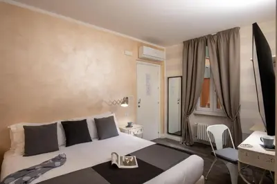 a bedroom with a large white bed and a desk at Spagna Secret Rooms in Rome
