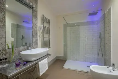 a bathroom with two sinks and a glass shower at Spagna Secret Rooms in Rome
