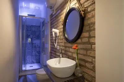 a bathroom with a sink and a toilet and a mirror at Spagna Secret Rooms in Rome