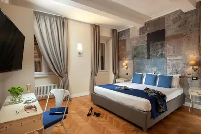 a hotel room with a large bed and a desk at Spagna Secret Rooms in Rome