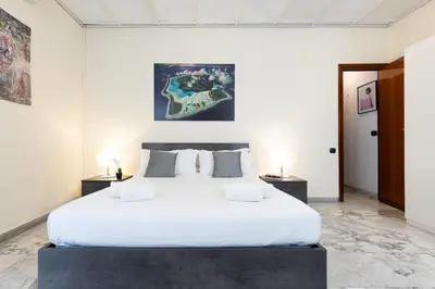 a bedroom with a large white bed with two tables at VATICAN Gregory Apartment in Rome