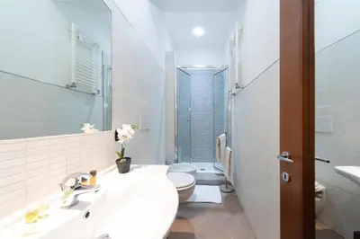 a white bathroom with a toilet and a sink at VATICAN Gregory Apartment in Rome