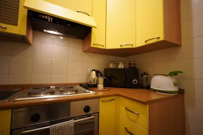 a kitchen with yellow cabinets and a stove at MGPgroup Guest House Navona 2 in Rome