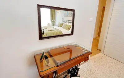 a mirror on a wall above a desk with a sink at Oksana's Bernadette Apartment in Rome