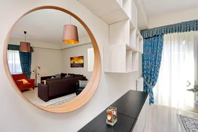 a living room with a large round mirror on the wall at Oksana's Bernadette Apartment in Rome