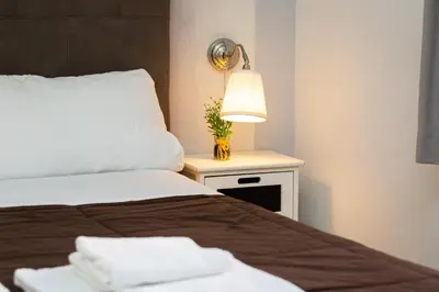 a bedroom with two beds and a lamp on a night stand at Termini Central Inn in Rome
