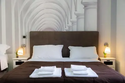 a bedroom with a large bed with two towels on it at Termini Central Inn in Rome