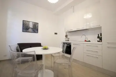a white kitchen with a white table and chairs at Patrizi 2/a in Rome
