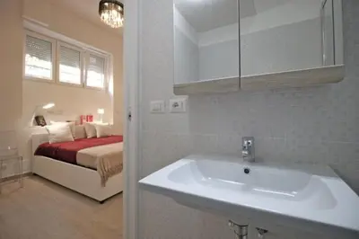 a bathroom with a sink and a bedroom with a bed at Patrizi 2/a in Rome
