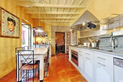 a large kitchen with white cabinets and a counter at Spectacular Luxury Flat in Trastevere in Rome