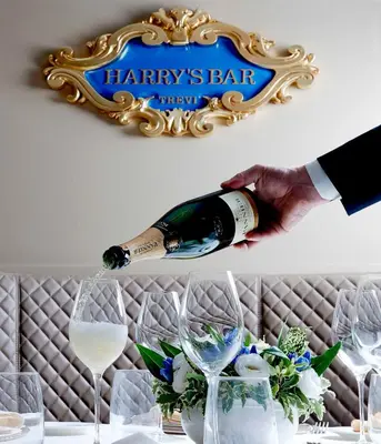 a bottle of wine being poured into a wine glass at Harry's Bar Trevi Hotel & Restaurant in Rome