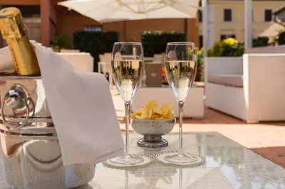 two glasses of champagne on a table with a bowl of chips at Harry's Bar Trevi Hotel & Restaurant in Rome