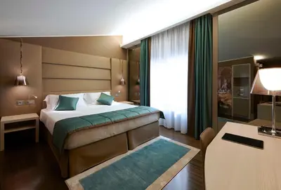 a hotel room with a bed and a desk at Harry's Bar Trevi Hotel & Restaurant in Rome