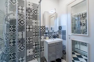 a bathroom with a black and white tiled wall at Vatican Stemar Apartment in Rome