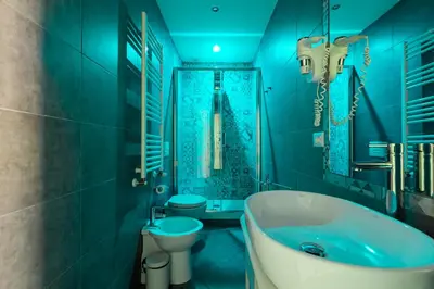 a blue bathroom with a tub and a toilet at Maison Degli Artisti Suites in Rome