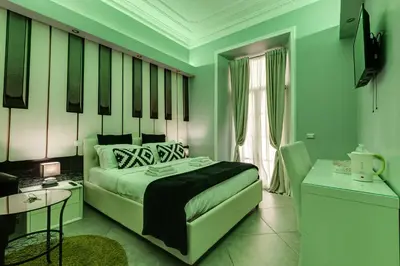a bedroom with green walls and a bed with a table at Maison Degli Artisti Suites in Rome