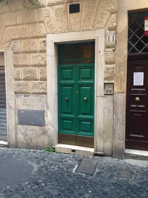 a green door on the side of a building at Small Navona Studio in Rome