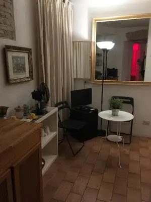 a living room with a table and a desk with a mirror at Small Navona Studio in Rome
