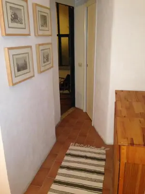 a hallway with a white wall and a rug at Small Navona Studio in Rome