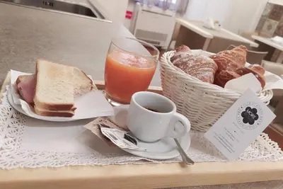 a tray with a sandwich and a cup of coffee and bread at More Cola di Rienzo B&B in Rome