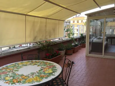 a patio with a table and chairs on a balcony at Attico Pavia vicino Policlinico in Rome