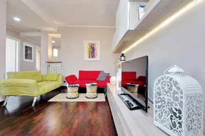 a living room with red and yellow couches at Attico Pavia vicino Policlinico in Rome