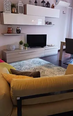 a living room with a yellow couch and a tv at Attico Pavia vicino Policlinico in Rome
