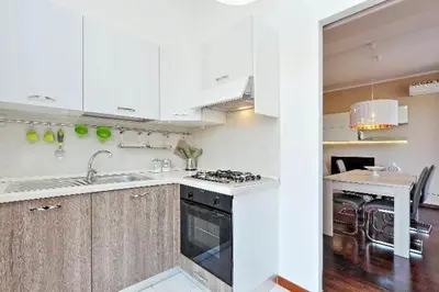 a kitchen with white cabinets and a stove top oven at Attico Pavia vicino Policlinico in Rome
