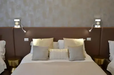 a bed with two pillows and two lights above it at At your Place in Rome
