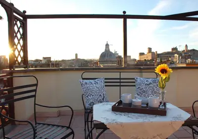 a table and chairs on a balcony with a view of the city at Panoramic Apartment in Rome