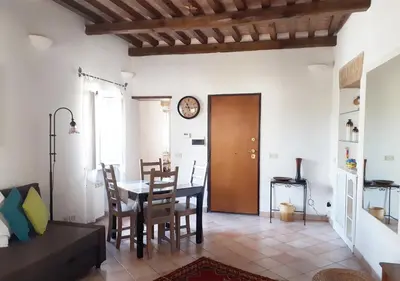 a dining room with a table and chairs and a clock at Panoramic Apartment in Rome